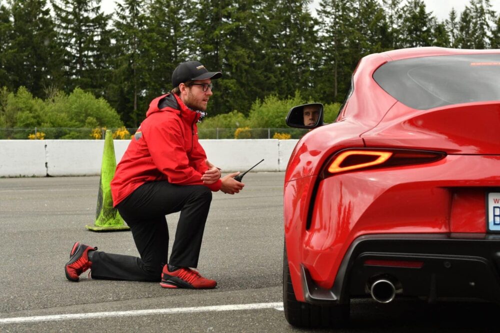 ProFormance instructor Colton Edwards kneeling on ground, advising driver