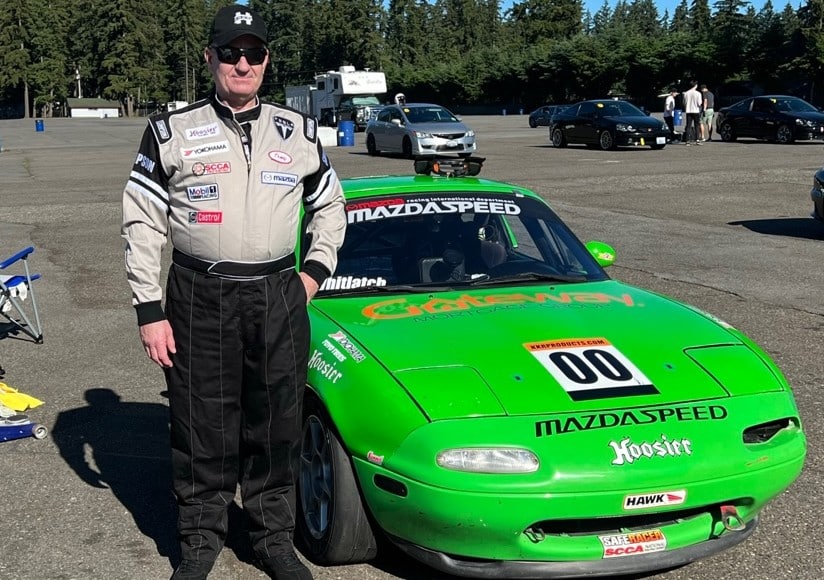 Tony Whitlatch standiing in front of a green Miata