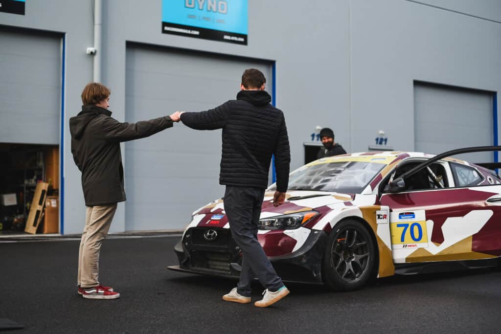 Colton Edwards and Will Morris bump fists as Hyundai Veloster is delivered to racing team headquarters.