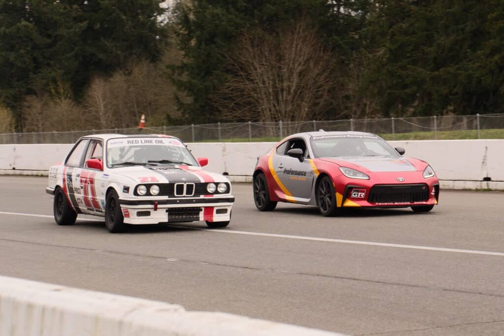 Two cars racing together in competition licensing course