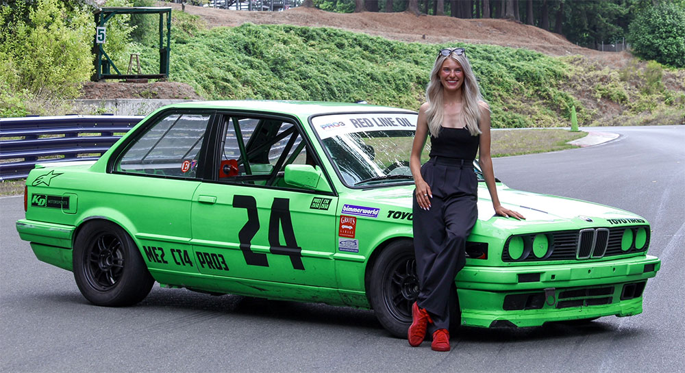 Siena Kitch, who is raising money for Seattle Children's, standing in front of her green race car