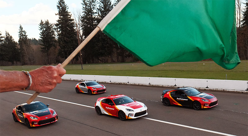 Card lined up at starting line at ProFormance Racing School as green flag waves to start them.