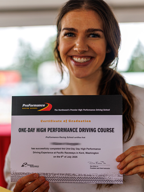 Smiling lady holding One-Day High Performance Driving Course diploma